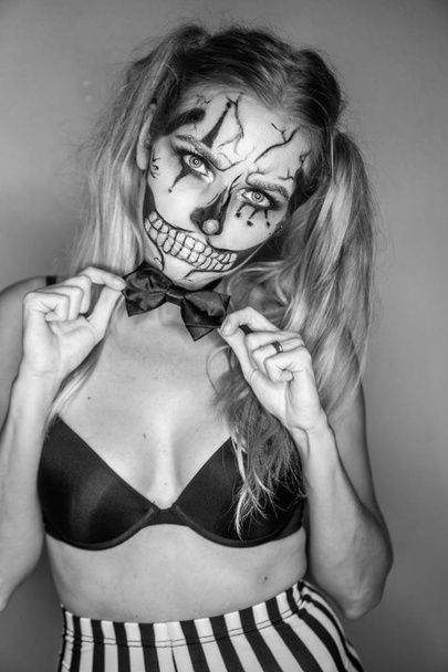 Donna con inquietante trucco del cranio clown di Halloween guardando nella fotocamera. Concetto creativo, artistico, Halloween - foto in bianco e nero
 - Foto, immagini