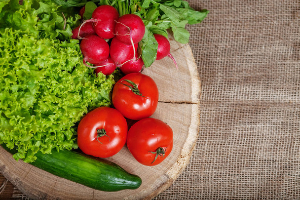 Surtido de verduras con pepinos, tomates, rábanos y lechuga. Vista superior. El concepto de alimentación saludable y vegetarianismo
. - Foto, imagen