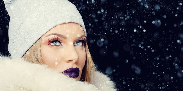 Portrait of young woman in wintertime outdoor Christmas background - Foto, afbeelding