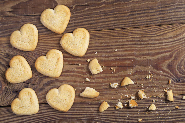 Cookies in the shape of a heart whole end broken on wooden background, top view - Photo, Image