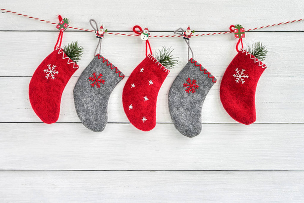 Κόκκινο και γκρι Χριστούγεννα κάλτσες σε λευκό φόντο ξύλινη. Χριστούγεννα ευχετήριας κάρτας. Χώρο αντίγραφο - Φωτογραφία, εικόνα