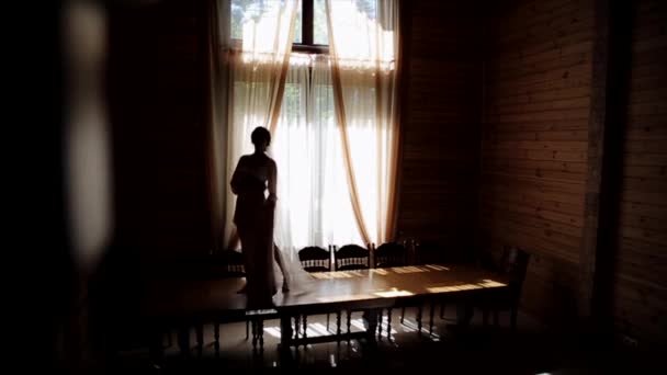 Mattina prima del matrimonio. Una sposa in pigiama e velo sta camminando sul tavolo con il suo abito da sposa
 - Filmati, video