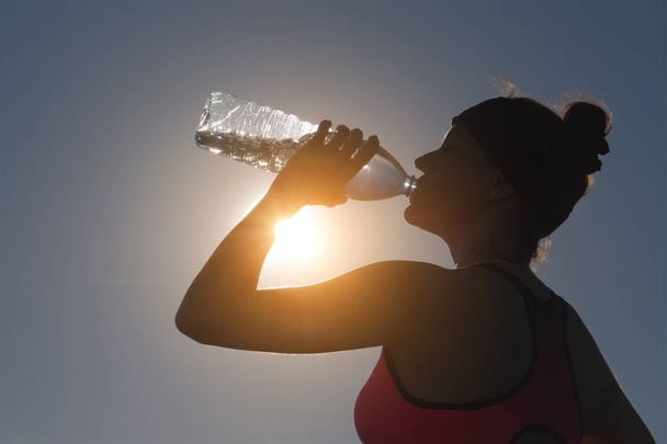 Sportswoman drinking water after training from bottle - Fotoğraf, Görsel