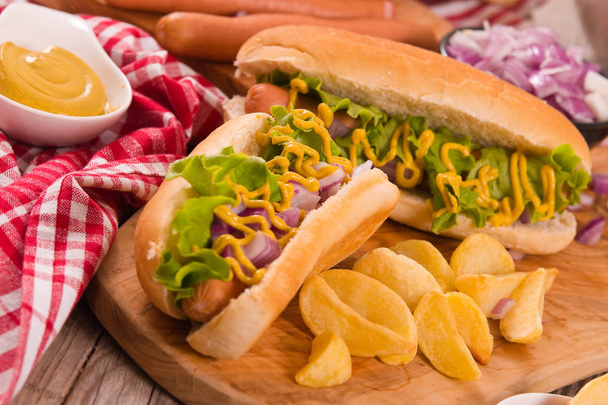 Hotdogs mit Pommes auf Holztisch. - Foto, Bild