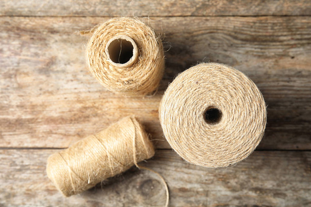 Natural hemp rope spools on wooden background, flat lay - Foto, Imagen