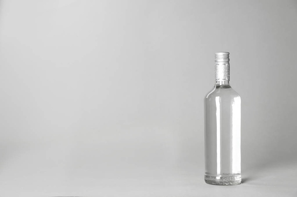 Bottle of alcoholic drink on grey background. Space for text - Foto, afbeelding