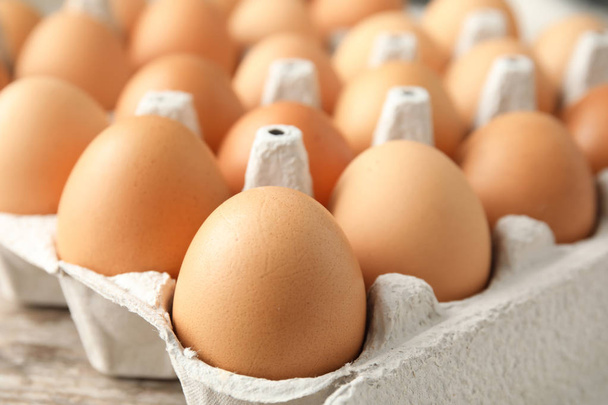 Raw chicken eggs in carton, closeup view - Foto, Imagem