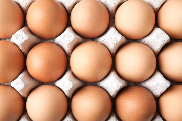 Raw chicken eggs in carton, top view - Foto, imagen