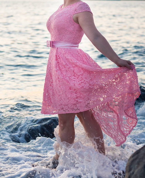 Tyttö vaaleanpunainen mekko vaahdossa aalto
 - Valokuva, kuva