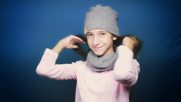 beautiful teen girl in autumn clothes , posing at camera over blue background - Materiał filmowy, wideo