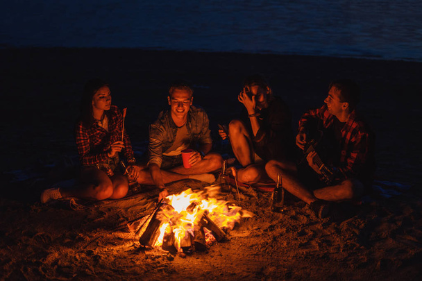jeunes amis ont pique-nique avec feu de joie sur la plage
 - Photo, image