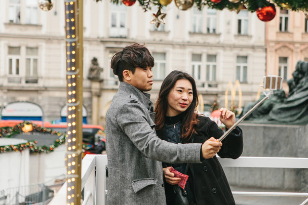 Jonge Aziatische paar nemen selfie in het geheugen van Praag in de Tsjechische Republiek tijdens de kerstvakantie. - Foto, afbeelding
