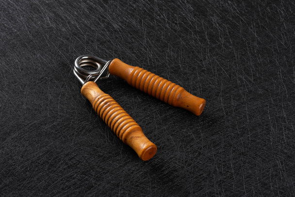 wooden handles hand trainer on dark background - Photo, Image