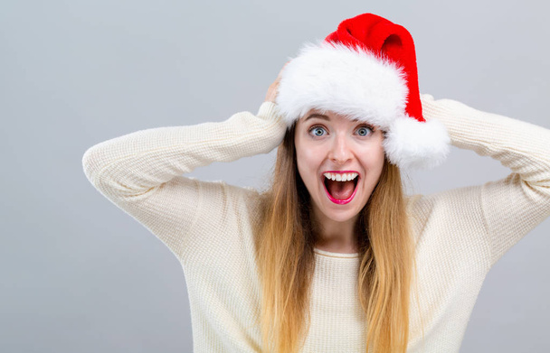 Young woman with a Santa hat making a mistake - Фото, изображение