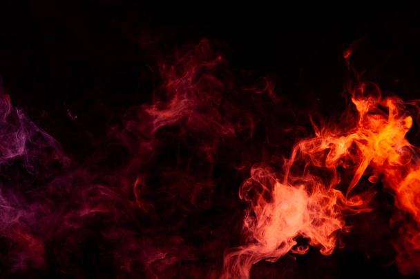 textueller Hintergrund für Kreativität. Dicker, bunter Rauch von rosa, rot auf schwarzem Hintergrund. Hintergrund aus dem Rauch des Vaps - Foto, Bild