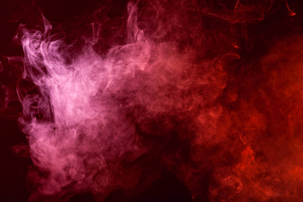 Fondo textural para la creatividad. Nube de humo rojo y rosa sobre un fondo negro aislado. Antecedentes del humo del vap
 - Foto, imagen