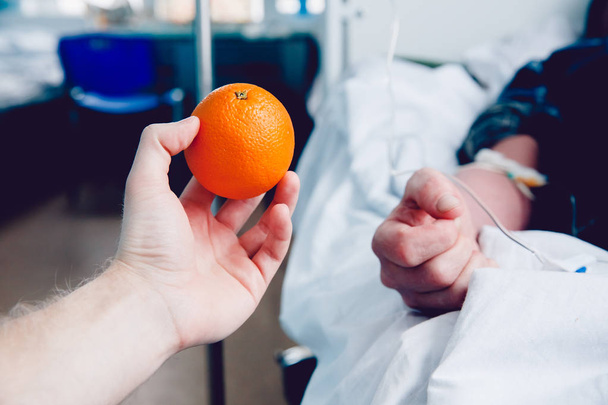 doctors hand holds the orange against the dropper - Photo, Image