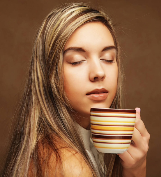 people and food concept: young pretty curly woman drinking coffee - Fotó, kép