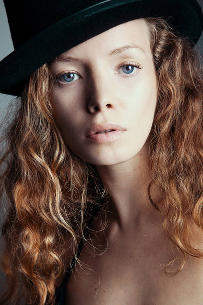portrait of attractive woman in black hat looking at camera, close-up  - Фото, изображение