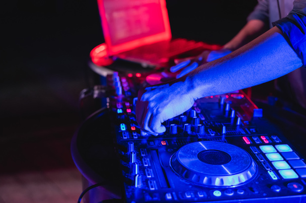 Concepts musicaux. DJ est une musique rythmique avec Controller et mixer. DJ joue la chanson à la fête. Les jeunes ajustent la musique avec le contrôleur. Le plaisir de la musique et des couleurs claires
. - Photo, image