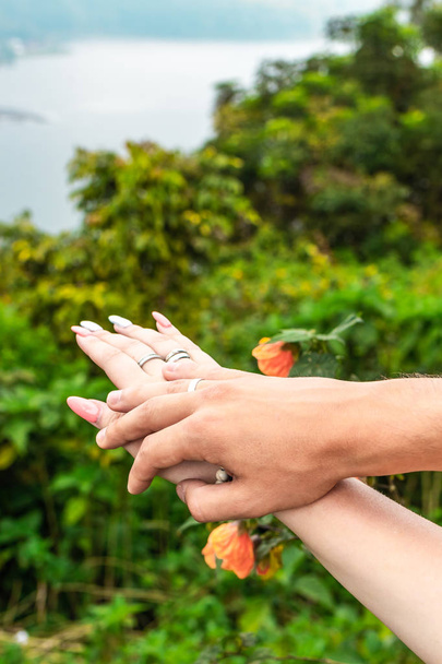 Honeymoon hands on the tropical lake background. Bali island. - Photo, Image