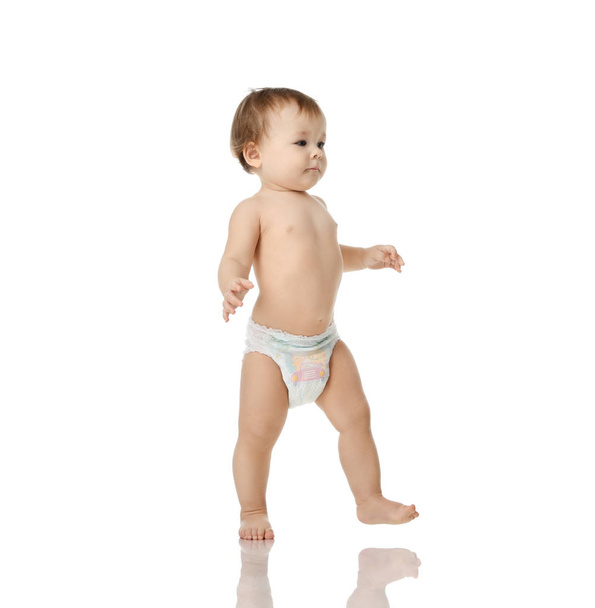 Infant child baby girl kid toddler in diaper  make first steps - Фото, зображення