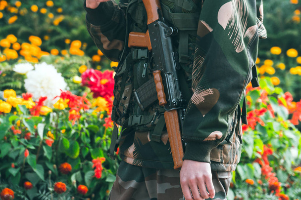 Um soldado segurando uma arma automática de cabeça para baixo durante a preparação do desfile do dia da República
 - Foto, Imagem