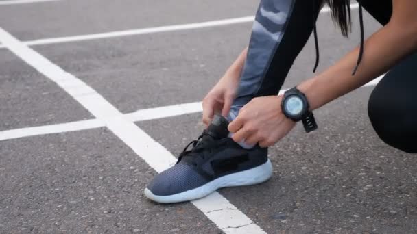 Nahaufnahme einer Läuferin, die ihre Schuhe schnürt - Filmmaterial, Video