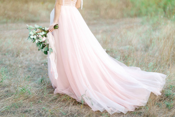 Beautiful bride with bouquet and dress with train - Zdjęcie, obraz