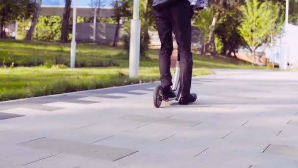 キック スクーターに乗ってビジネス スーツを着た男の足 - 映像、動画