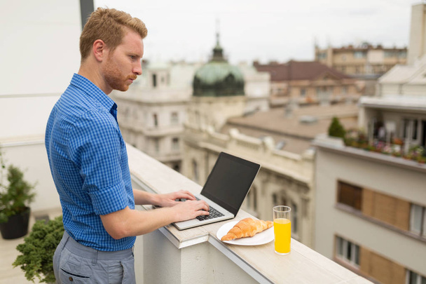 Business person using laptop outdoors  on rooftop - Valokuva, kuva
