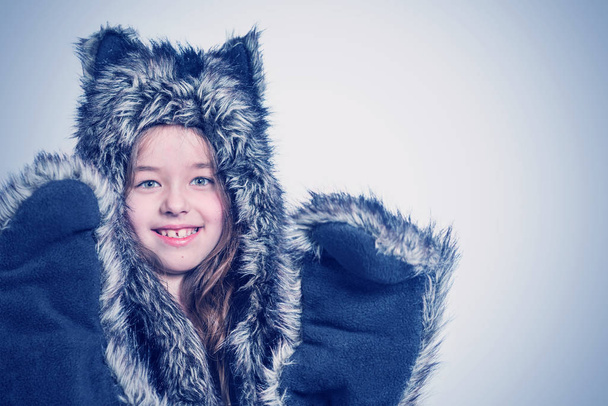 Little girl in a fur hat with cat's ears. Toned - Photo, image