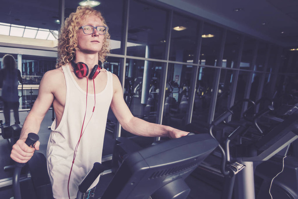 Thin curly blond man in glasses on the speedwalk - Photo, Image