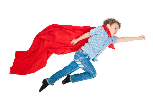 Boy flying in a red cloak of superhero on a white background. Isolated - Φωτογραφία, εικόνα
