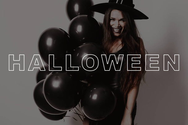 Cheerfully Laughs. Black Balloons. Halloween. Party. Smile. Black Dress. Joyful. Sexy. Witches. Laughs. Hats. Confetti. Bats. Magic. Fun. Fashion. Pretty. Lady. Makeup. Stylish. Gothic. Cosmetic. - Zdjęcie, obraz