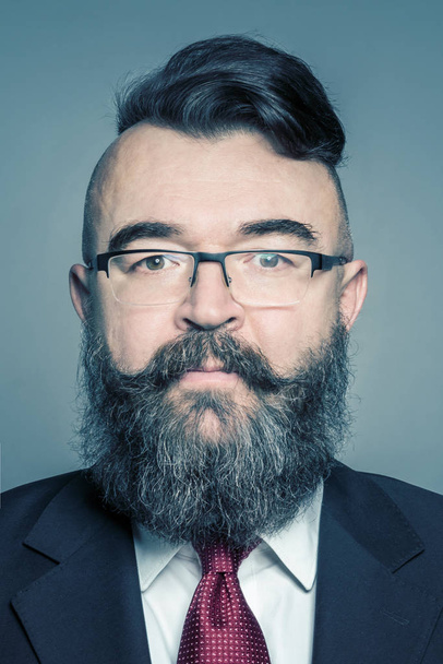 Adult bearded man in a suit and glasses with mohawk hairstyle - Фото, изображение