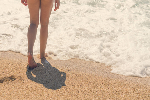 Female feet emerging from the sea - Φωτογραφία, εικόνα