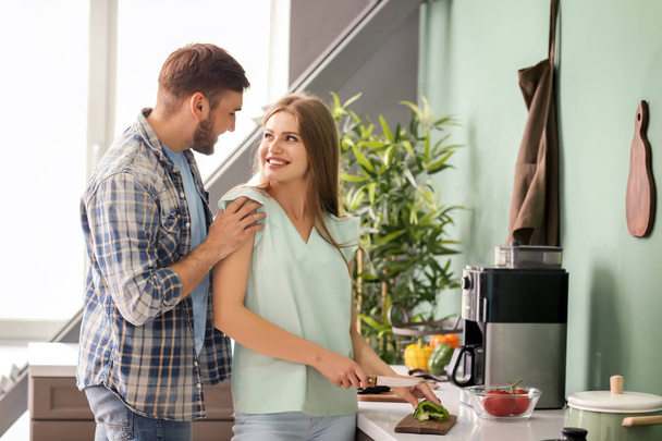 Happy young couple cooking together in kitchen - Photo, Image