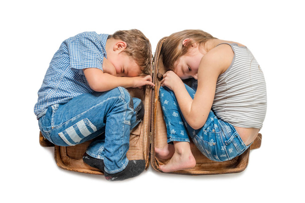 Boy and girl lying in a suitcase on a white background. Isolated - Foto, Imagem