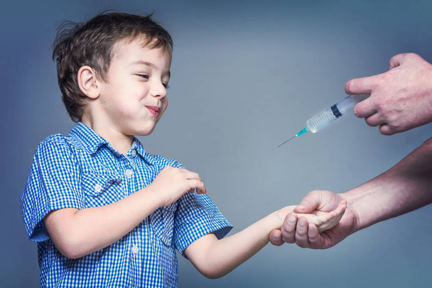 Boy in the blue shirt during vaccination. Toned - Φωτογραφία, εικόνα