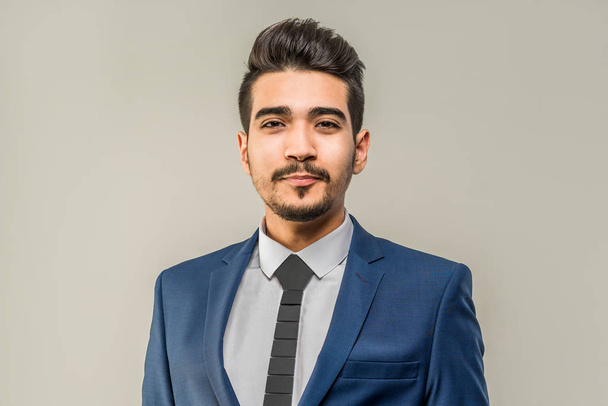 Young attractive man in a blue suit on a gray background. Isolated - Foto, Imagen