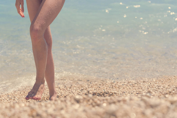 Female feet emerging from the sea - 写真・画像