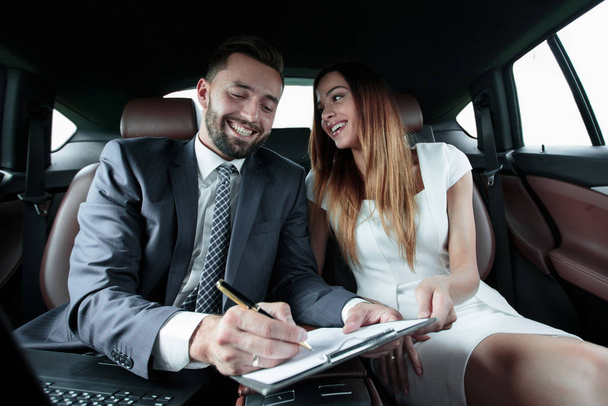 Beautiful business woman working with a client in the car - Foto, imagen
