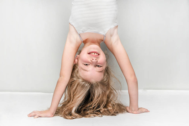 Little girl  in a blue shirt upside down - Valokuva, kuva