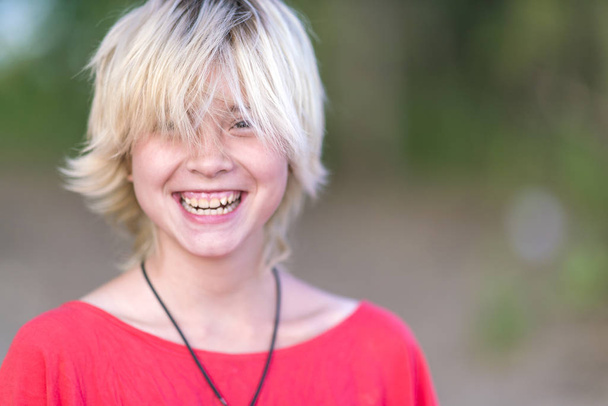 Portret Blondynka w czerwonej bluzce z uśmiechem w słoneczny dzień - Zdjęcie, obraz
