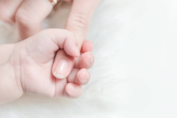 Hand van een baby houdt een vrouw vinger - Foto, afbeelding