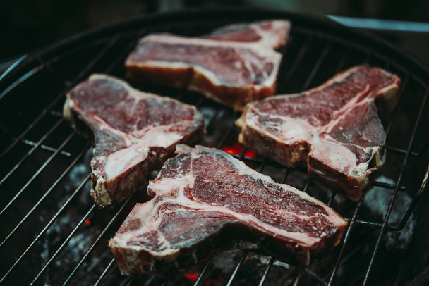 Aged t-bone beef steaks cooking. Grill and BBQ or barbecue season concept - Fotoğraf, Görsel
