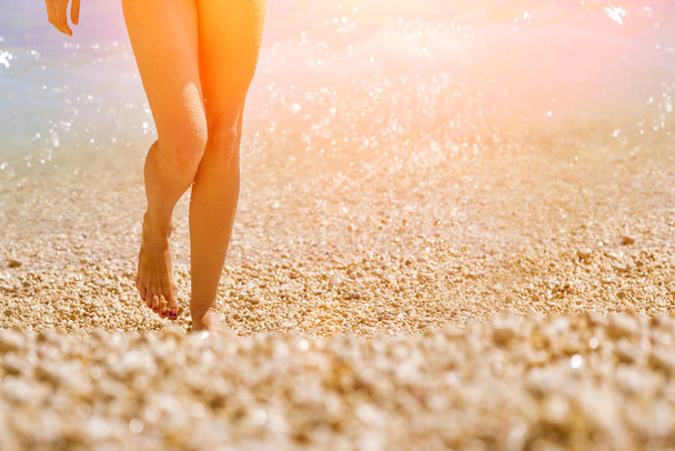 Female feet emerging from the sea  in the sunlight - Foto, Imagem