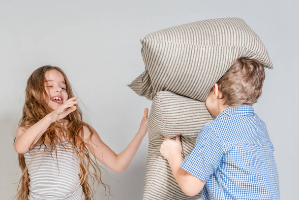 Menino e menina lutar com travesseiros
 - Foto, Imagem