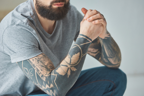 plan recadré d'homme barbu avec des tatouages en t-shirt gris
 - Photo, image